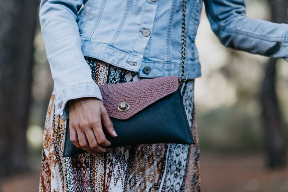 bolso rosa tipo sobre con animal print y cadenas, bandoleras con cadenas y estampado de serpiente, bolsos bonitos hechos en españa de moda